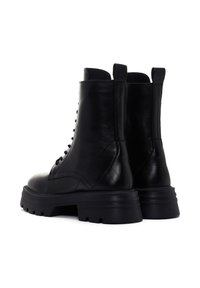 Stivali alla caviglia in pelle nera con texture liscia, punta rotonda e suola robusta, dotati di zip laterale e linguetta sul retro per una facile vestibilità.