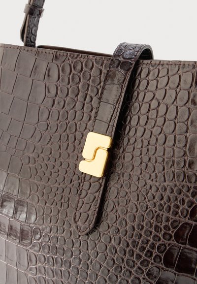 Καφέ δερμάτινη τσάντα με ανάγλυφο μοτίβο κροκόδειλου και χρυσό ορθογώνιο κούμπωμα σε κλεισίματος με λουράκι.