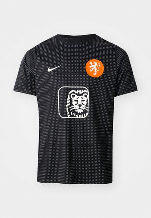 Maglietta da calcio nera Nike con texture a pois, emblema di leone arancione e logo di leone bianco sul fronte, maniche corte e scollatura a girocollo.