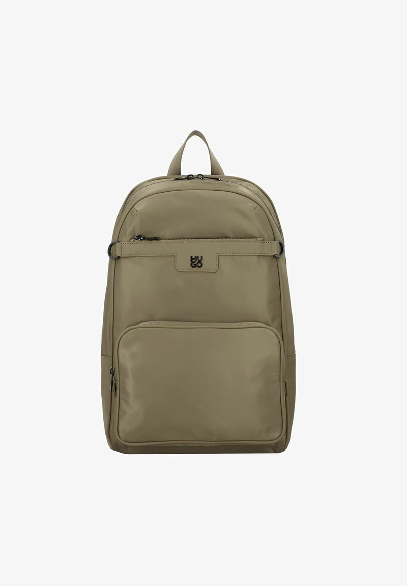 Mochila de nailon beige con una textura suave, que cuenta con un asa superior, compartimentos con cremallera y un logo en el panel frontal.