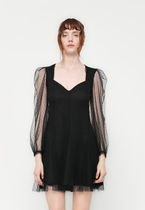 Black dress with a fitted bodice, puffed sheer sleeves in a dotted texture, A-line skirt, and a V-neckline. Simple design with elegant details.