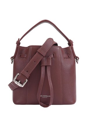Sac seau en cuir bordeaux avec une forme structurée, une bandoulière réglable et des accents en métal argenté. Comprend une fermeture à cordon et un logo en relief.