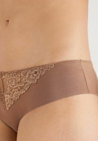 Braune Hipster-Unterhosen aus weichem Stoff mit einem Spitzenbesatz auf einer Seite, verziert mit floralen Mustern und einem glatten Bund.