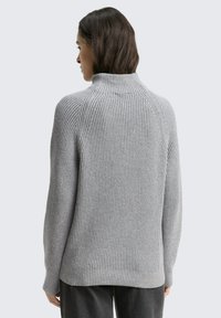 Gray ribbed sweater with a high collar, featuring a relaxed fit, dropped shoulders, and textured knit pattern. Displayed from the back.
