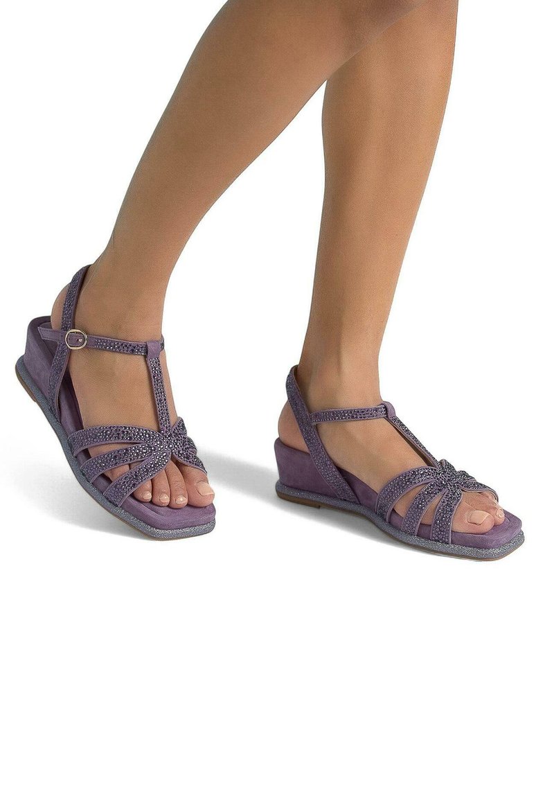 Sandalias de cuña moradas con un diseño de tiras en T, con correas texturizadas y un detalle de nudo. La suela tiene una ligera textura para mayor agarre.