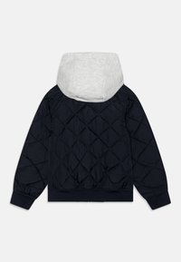 Námořnická prošívaná bunda s lehce šedou kapucí. Má elastické manžety a lem, což zajišťuje přiléhavý střih. Texturovaný diamantový vzor po celé ploše.