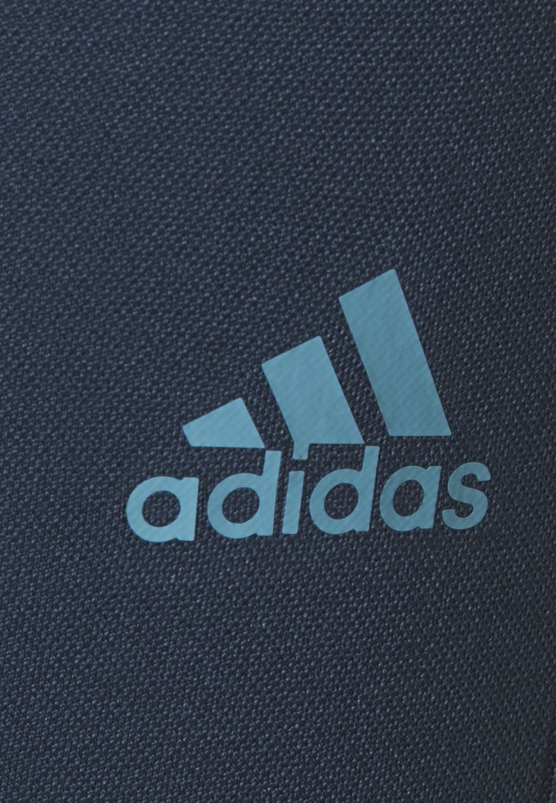 Tejido azul marino con una textura suave que presenta un logo de Adidas en azul claro con tres franjas y la palabra "adidas" en minúsculas.
