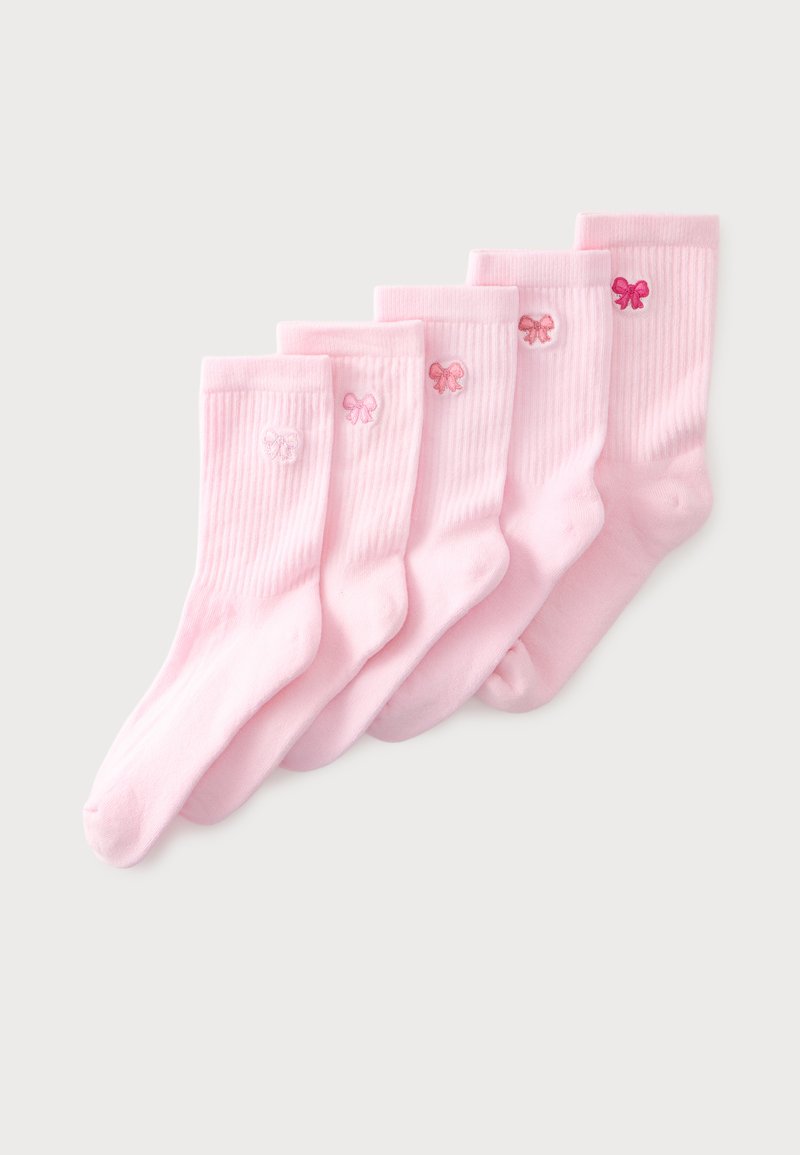 Cinq paires de chaussettes roses côtelées alignées, chacune ornée d’un petit nœud brodé dans différentes nuances de rose près du haut du revers.