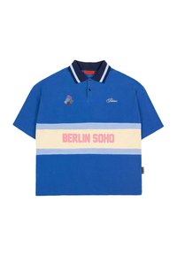Blå bomulds polo shirt med marineblå krave, med blomsterbroderi og horisontale striber i lyseblå og beige, der viser "BERLIN SOHO" i pink.
