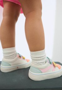 Kolorowe dziecięce sneakersy z mieszanką różowych, niebieskich i pomarańczowych akcentów. Rzepy, gładkie tekstury i masywna biała podeszwa.