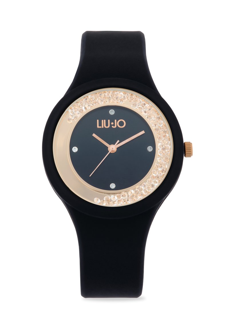 Orologio in silicone nero con quadrante rotondo, accenti color oro e una lunetta decorata con cristalli. Presenta un quadrante scuro con lancette e indici in oro rosa.