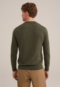 Sötétzöld pulóver hosszú ujjakkal és kerek nyakkivágással. A pulóver puha tapintású és karcsú derékpánttal rendelkezik.