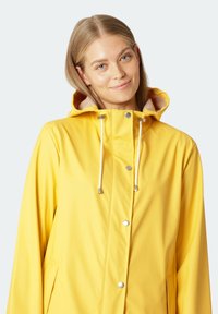 Geel waterdichte regenjack met capuchon, witte trekkoorden, drukknoopsluiting en zijzakken. Glad textuur en casual ontwerp.