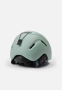 Jasnozielony kask o gładkim matowym wykończeniu, z regulowanymi paskami, otworami wentylacyjnymi i czarnym paskiem z tyłu.