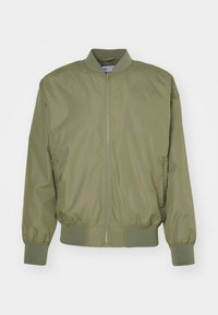 Giacca bomber verde oliva realizzata in tessuto leggero e liscio, dotata di zip frontale, polsini a coste e due tasche laterali.