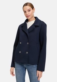 Marineblaues, doppelt geknöpftes Jacket aus weichtem Stoff mit gro�ßen Knöpfen und Reverskragen, ausgestattet mit seitlichen Taschen und einem lockeren Schnitt.