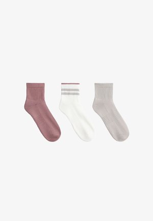 Tre calzini alla caviglia in rosa polvere pieno, bianco con due strisce grigie e rifinitura rosa, e grigio chiaro pieno, disposti affiancati su sfondo bianco.