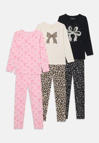 Cuatro conjuntos de pijamas que presentan varios diseños: rosa con lazos, crema con un lazo de estampado de leopardo, negro con gráfico de lazo plateado y negro con estrellas.