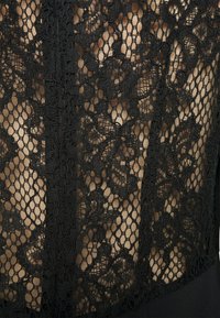 Μαύρο δαντελένιο ύφασμα με floral σχέδιο που καλύπτει ένα ενιαίο μαύρο υπόστρωμα. Διαθέτει κουμπωτές άκρες και φερμουάρ στη μέση.