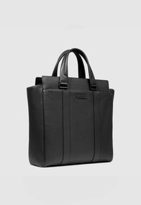 Borsa tote in pelle nera con design strutturato, dotata di doppi manici, cuciture verticali e un sottile dettaglio con logo. Texture liscia.