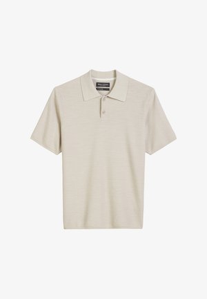 Beige polo shirt made of textured fabric. Features a classic collar, three-button placket, and short sleeves.