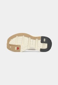 Sål for fottøy med et mønster av flerretninger. Fargene inkluderer krem, brun og svart. Teksturert gummi for grep og støtte.