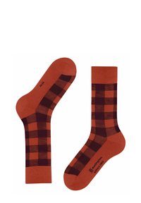 Gemusterte Crew-Socken in rostorange mit einem dunkelburgunderfarbenen karomuster. Hergestellt aus einem glatten Stoff, der kontrastierende einfarbige Abschnitte aufweist.