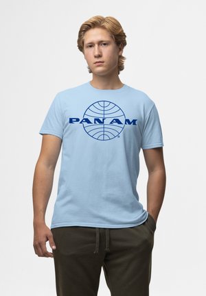 Hellblaues Baumwoll-T-Shirt mit einem dunkelblauen "PAN AM"-Logo und einem Globus-Design auf der Vorderseite. Kurze Ärmel und Rundhalsausschnitt.