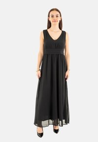 Robe maxi noire avec un décolleté en V, sans manches et taille empire. Fabriquée dans un tissu léger avec une silhouette fluide.