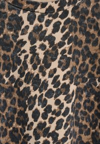 Leopard print fabric featuring irregular black and brown spots on a beige background, with a soft texture and a round neckline.