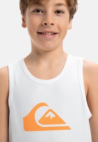 Witte katoenen tanktop met een groot oranje golflogo en een bergontwerp, ronde halslijn en zonder mouwen.