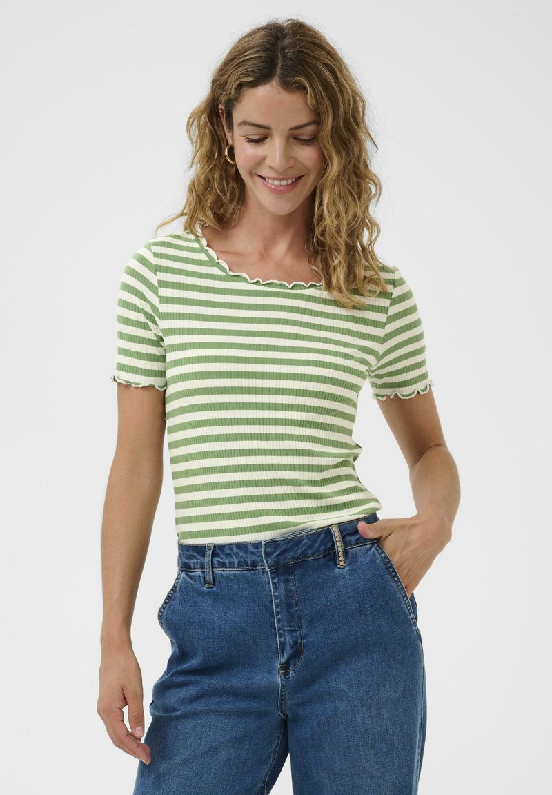 Grün-weiß gestreiftes T-Shirt mit geschwungenem Ausschnitt und kurzen Ärmeln, kombiniert mit hoch taillierten blauen Denim-Jeans.