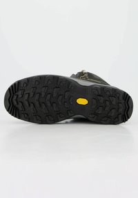 Schwarze Gummi-Sohle mit tiefen Profilmustern und einem gelben Vibram-Logo, konzipiert für Traktion und Haltbarkeit, mit einer strukturierten Oberfläche.