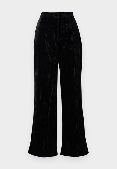 Pantalons larges en velours noir avec une texture douce, présentant une taille haute et de subtils rayures verticales. Conçus pour une coupe décontractée.