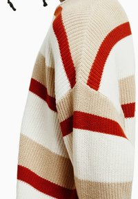 Stickad tröja med breda horisontella ränder i röd, beige och kräm. Den har en lös passform med en texturerad väv och ribbade detaljer.