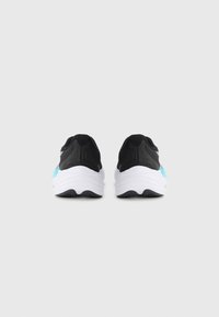 Schwarze Sportschuhe mit einem strukturierten Obermaterial, ausgestattet mit einer weißen Zwischensohle und hellblauen Akzenten an der Ferse. Rundliche Form und robuste Gummisohle.