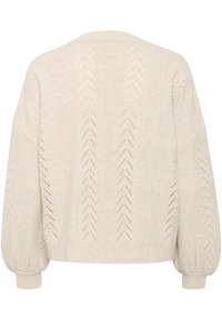 Strikket cardigan i lys beige med et tekstureret mønster og zigzagudskæringer. Overdimensionerede ærmer og en afslappet pasform er tydelige.