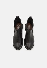 Botas de tobillo de cuero negro con laterales elásticos, puntera redondeada y plantillas texturizadas con el logotipo. Acabado suave, diseño minimalista.