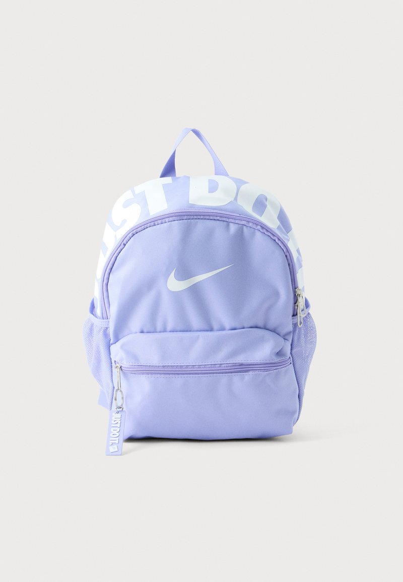 Светлолилав раница Nike с предни и странични джобове, бял текст "Just Do It" в горната част и бял лого Nike swoosh на предния джоб.
