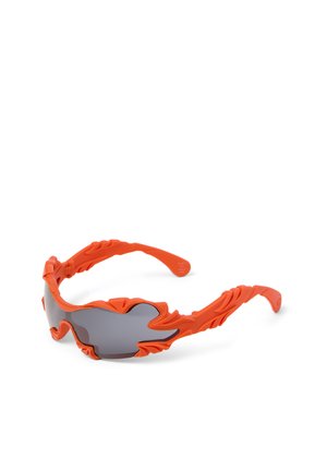 Pomarańczowe sportowe okulary przeciwsłoneczne z rzeźbionymi detalami ramki przypominającymi płomienie oraz ciemnymi, przyciemnianymi soczewkami owijającymi się dookoła.