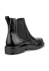 Black leather Chelsea boots with elastic side panels, brogue detailing on the toe, and a black rubber sole. Smooth texture, ankle height.