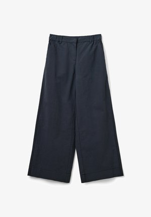 Tumed jalad, tume navy, valmistatud kergest kangast. Omab tasasest eesmist osa, elastset vöökohta ja lühendatud ääri pahkluude tasemel.