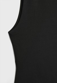 Débardeur noir en tissu lisse et extensible, avec une coupe près du corps et des coutures minimales pour un design épuré.