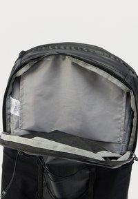 Μαύρο σακίδιο με κορυφή που κλείνει με φερμουάρ. Το εσωτερικό διαθέτει ομαλή γκρι επένδυση και μια μικρή τσέπη. Ρυθμιζόμενα κορδόνια στο εξωτερικό για βελτίωση.