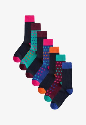 Set aus sieben knielangen Socken mit verschiedenen einfarbigen Farben und Polka-Dot-Mustern. Die Farben umfassen Marineblau, Türkis, Burgunderrot und leuchtende Akzente.