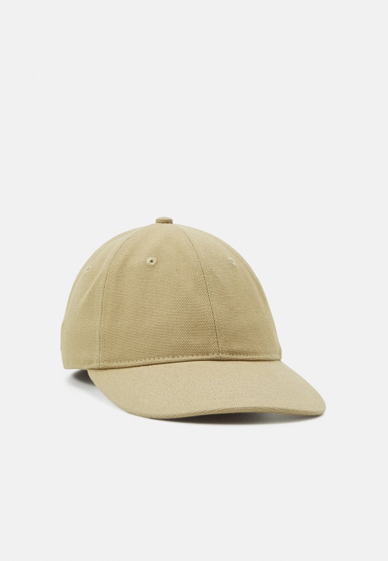 Casquette de baseball beige en coton avec panneaux cousus et visière courbée sur un fond uni clair.