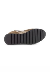 Bruine suede laars met een rubberen zool, voorzien van een zigzagloopvlak en een zijrits. Het bovenwerk heeft contrasterende tan accenten.