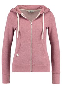 Sudadera con cremallera en rosa polvo para mujer, con cordones blancos, bolsillos tipo canguro en la parte frontal, puños y dobladillo acanalados, presentada sobre fondo blanco.