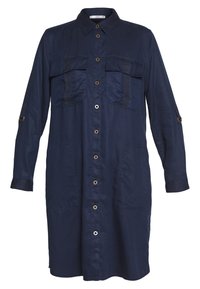 Navyblaues Hemdkleid mit langen Ärmeln, zwei Brusttaschen und goldfarbenen Knöpfen. Glattes Material mit einem legeren Schnitt.