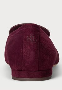 Burgundowe zamszowe kapcie o zaokrąglonym kształcie, z gładką, miękką fakturą i wytłoczonym logo "RL" z tyłu. Płaska podeszwa.
